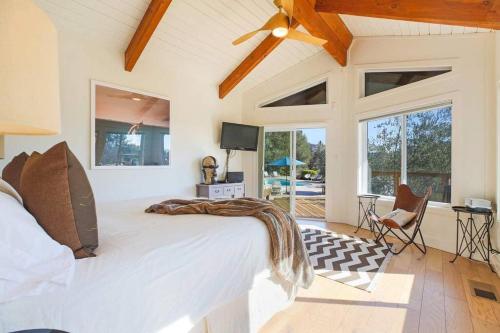 a bedroom with a large white bed in a room with windows at Trinity By Palm House Hospitality Stays in Glen Ellen