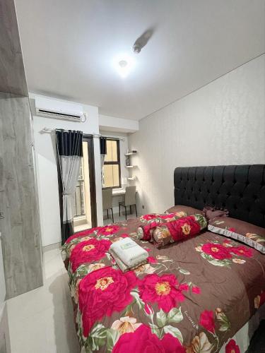ein Schlafzimmer mit einem Bett mit roten Blumen darauf in der Unterkunft apartemen transpark cibubur by trend property in Kalimanggis
