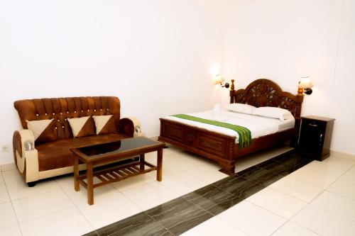 a bedroom with a bed and a couch at Hotel Green Prundi in Labuan Bajo