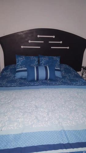 a bed with blue and white pillows on it at Q'entiHospedaje zaguan del cielo 2 in Cusco