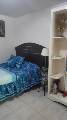 1 dormitorio con 1 cama con sábanas azules y lámpara en Q'entiHospedaje zaguan del cielo 2 en Cuzco