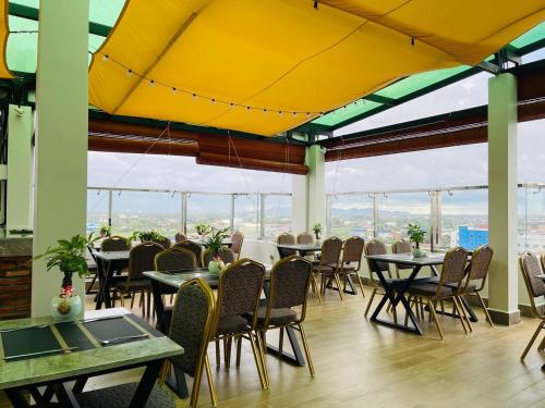 un restaurant avec des tables et des chaises et un plafond jaune dans l'établissement The Square Kampot Hotel, à Kampot