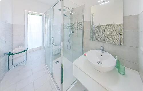 ein weißes Bad mit einem Waschbecken und einer Dusche in der Unterkunft 1 Bedroom Nice Apartment In Marzamemi in Marzamemi