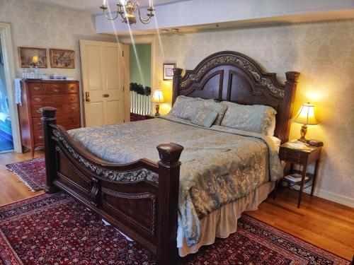 een slaapkamer met een groot houten bed in een kamer bij Montague Inn Bed & Breakfast in Saginaw
