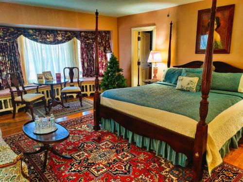 ein Schlafzimmer mit einem Bett, einem Tisch und einem Schreibtisch in der Unterkunft Montague Inn Bed & Breakfast in Saginaw