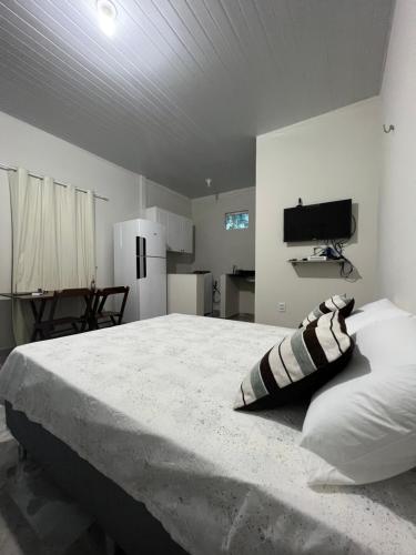 a bedroom with a large bed and a kitchen at APARTAMENTO MOBILIADO in Boa Vista