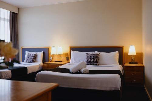 a hotel room with two beds and two lamps at Comfort Inn Traralgon in Traralgon