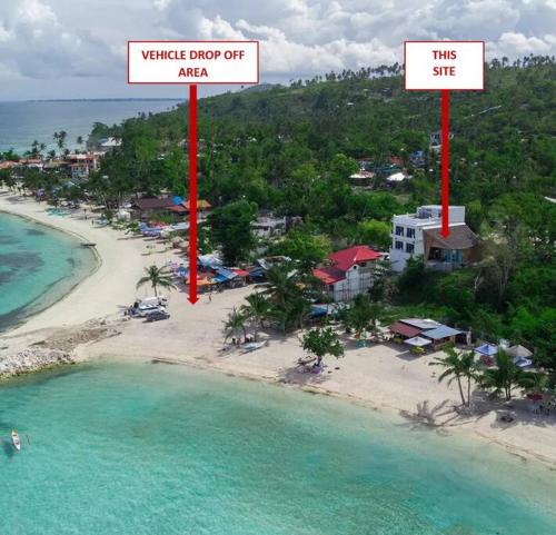 an aerial view of a beach with two red signs at The Verge Cebu Beachfront King Bed Pool Villa - 12 Minutes to Kawasan Falls Canyoneering in Badian