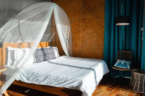 a bedroom with a bed with a mosquito net at The Verge Cebu Beachfront King Bed Pool Villa - 12 Minutes to Kawasan Falls Canyoneering in Badian