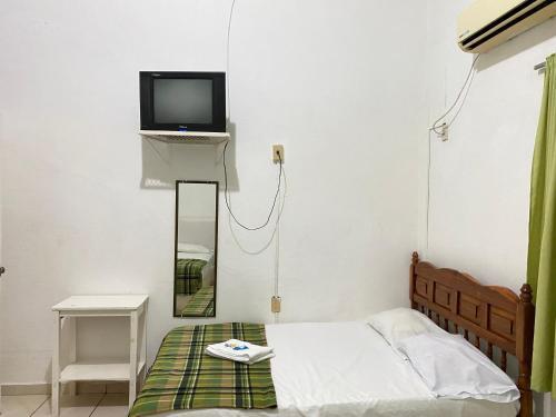 een slaapkamer met een bed en een tv aan de muur bij HOTEL RESTAURANT CASA DEL REY!!! in Arriaga