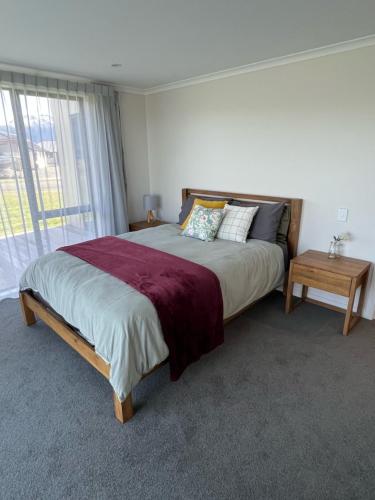 um quarto com uma cama grande e uma janela em The Little Lake House em Te Anau