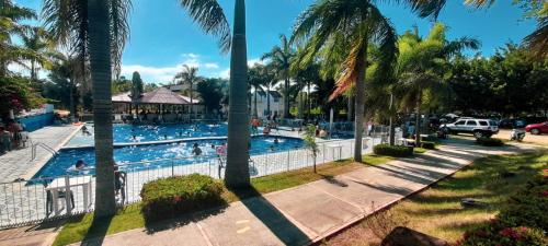 約帕爾的住宿－RIOPARK BEACH HOTEL，一座棕榈树游泳池,里面的人
