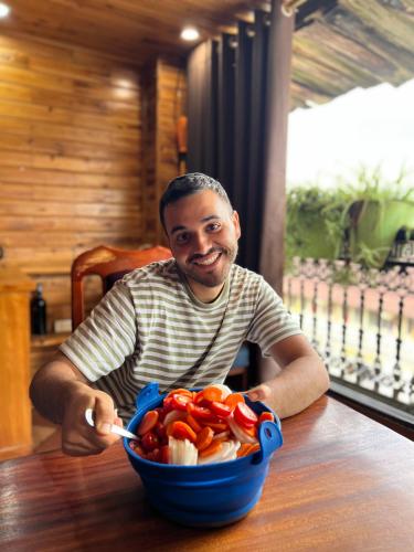 un uomo seduto a un tavolo con una ciotola di peperoni di SAPA FULL HOUSE HOTEL a Sa Pa