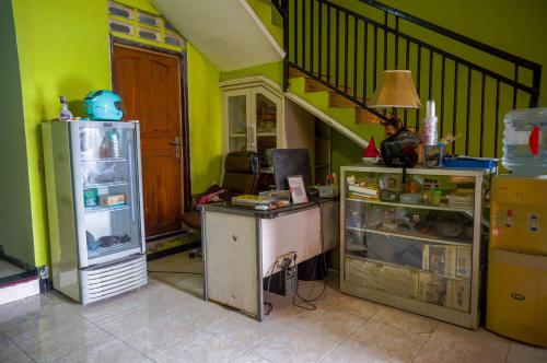 泗水的住宿－OYO 93069 Penginapan Sumber Rizki，带冰箱和楼梯的厨房