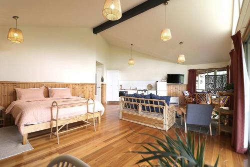 a bedroom with a bed and a living room at Hakuna Matatah - Rural escape on the coast in Tura Beach