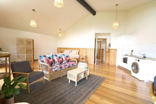 a living room with a couch and a table at Hakuna Matatah - Rural escape on the coast in Tura Beach