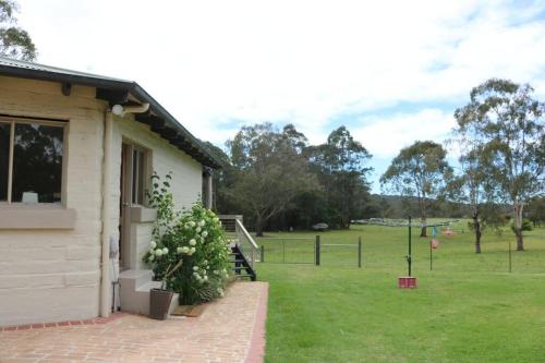 a house with a field in the background at Hakuna Matatah - Rural escape on the coast in Tura Beach