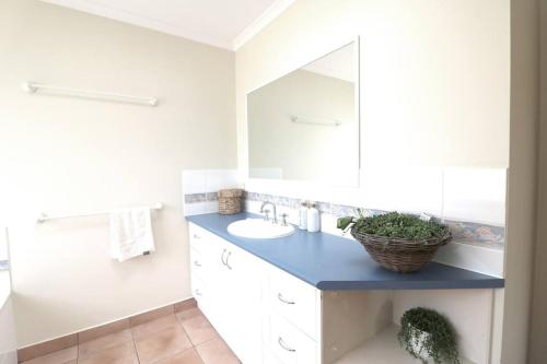 a bathroom with a sink and a mirror at Hakuna Matatah - Rural escape on the coast in Tura Beach