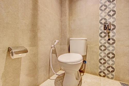 La salle de bains est pourvue de toilettes avec un tuyau. dans l'établissement Townhouse Oak IXO Hotel, à Semarang