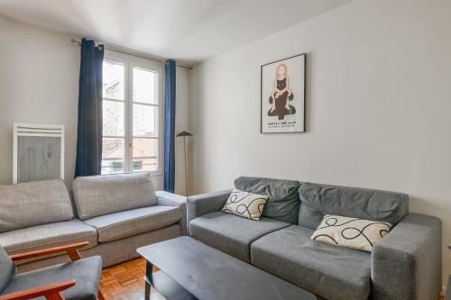 un salon avec un canapé et une table dans l'établissement Appartement Garnet - Welkeys, à Paris