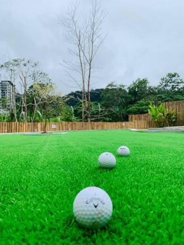 three golf balls on the grass in a yard at The White Box Villa - Genting Highland Foot Area in Bentong