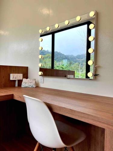 a mirror with a white chair in a room at The White Box Villa - Genting Highland Foot Area in Bentong