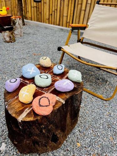 a group of colorful rocks sitting on top of a tree stump at The White Box Villa - Genting Highland Foot Area in Bentong