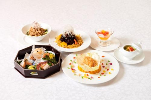 a table with plates of food and cups of drinks at Hotel Marroad Tsukuba in Tsuchiura