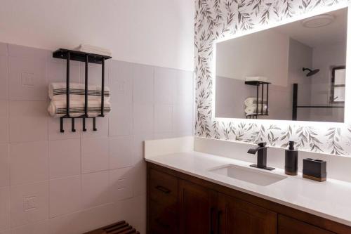 een badkamer met een wastafel en een spiegel bij Zoka House 5 mints from Brickell in Miami