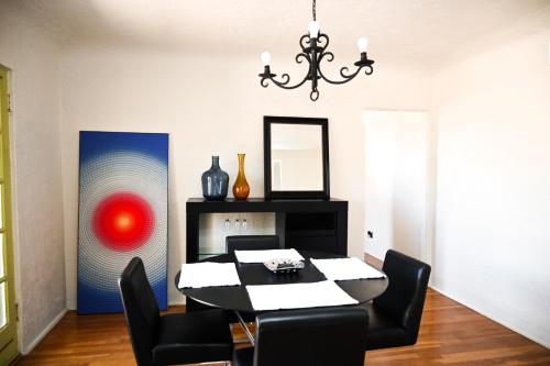 a dining room with a table and chairs and a mirror at Casita Kern in El Paso