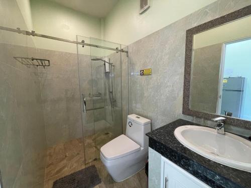 a bathroom with a toilet and a sink and a shower at Blue Beach Bungalow in Bang Saphan Noi