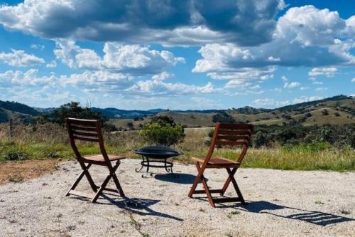 two chairs and a picnic table on a dirt field at Amethyst - 1 Bed with Hot Tub - Kundalini Lodge in Grattai