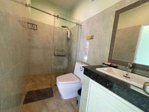 a bathroom with a shower and a toilet and a sink at Blue Beach Bungalow in Bang Saphan Noi