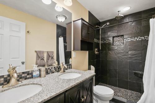 a bathroom with a sink and a toilet and a shower at Centrally Located- 4BR Home- Amenities Galore in Spokane Valley