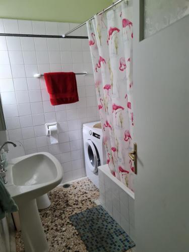 a bathroom with a toilet and a sink and a shower curtain at Center City Apt in Chios