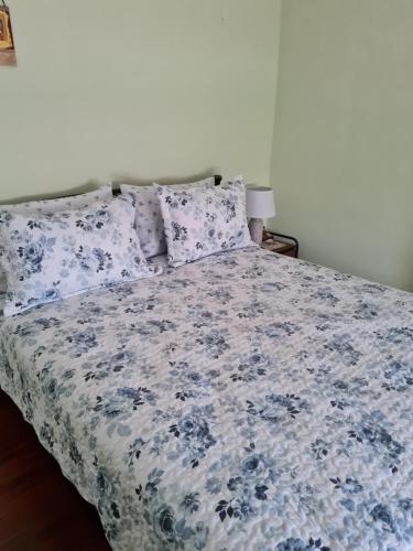a bed with a blue and white blanket and pillows at Center City Apt in Chios