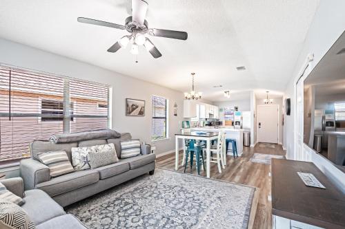 - un salon avec un canapé et un ventilateur de plafond dans l'établissement Surfside Cottage near Navarre Beach, à Navarre