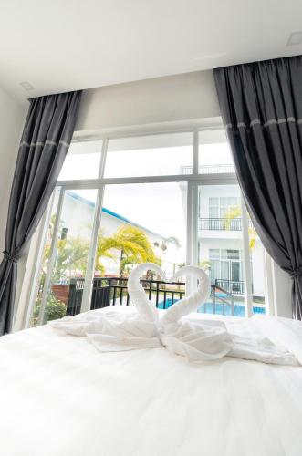 a bedroom with a bed with a large window at Koh Dach View Boutique Hotel in Phnom Penh