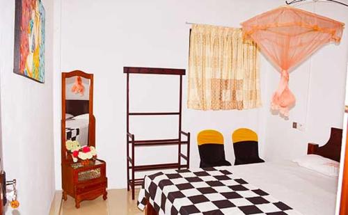 una camera con un letto con una coperta a scacchi di Relax Guest House a Batapola