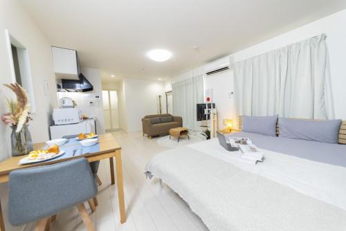 - une chambre avec un lit, une table et une chaise dans l'établissement FL Residence Takadanobaba, à Tokyo