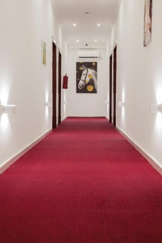 a red carpeted corridor with white walls and a red carpet at Hotel Totara in Dar es Salaam