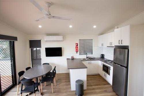 a kitchen with a table and chairs and a dining room at Airport Tourist Village Melbourne in Melbourne