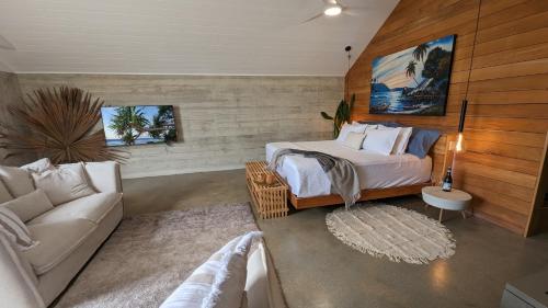 a living room with a bed and a couch at Bombua Beach House in Luganville