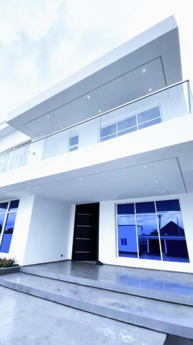 Casa blanca con puerta y ventanas negras en Contemporary 4-Bedroom Villa with VR Room and Starlink Internet - Ifemide Estates, en Akure