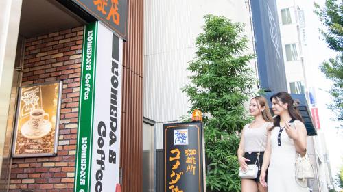 two young women standing outside of a building at Vessel Inn Sakae Station in Nagoya