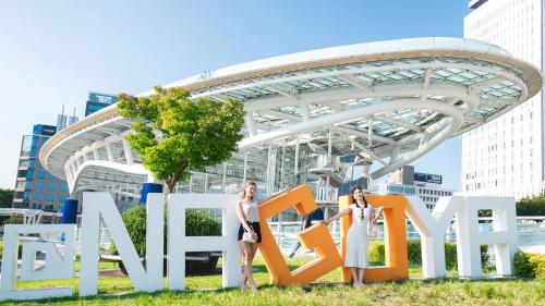 two women standing in front of the marvel sign at Vessel Inn Sakae Station in Nagoya