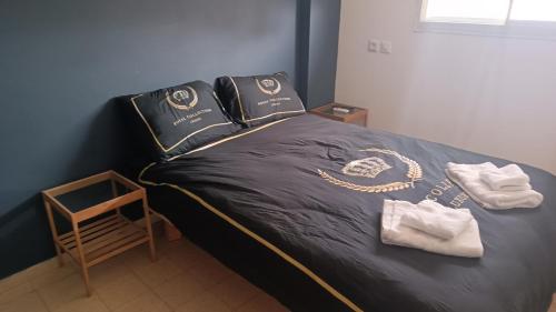 a bed with a black comforter with a chain on it at דירת אירוח בית שיאים in Beer Sheva