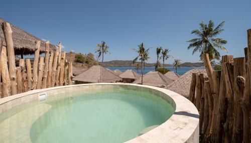 a swimming pool in front of a resort at Bleu MATHIS Gili Asahan in Gili Asahan