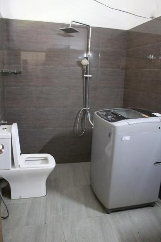 een badkamer met een douche, een toilet en een wastafel bij Cinty Guest House in Dambulla