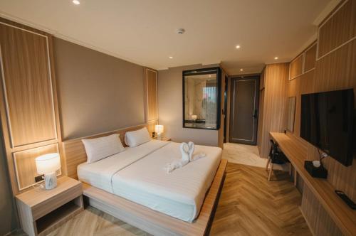 una camera con letto e TV a schermo piatto di Carrara Hotel Hatyai a Hat Yai